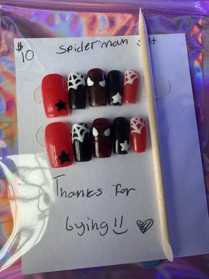 Red and black Spider-Man press-on nails with webs and stars